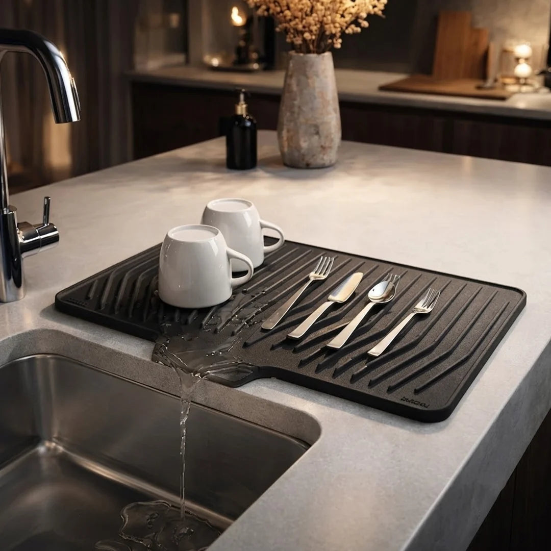 Anti slip silicone drain mat with cups and cutlery draining water into the kitchen sink