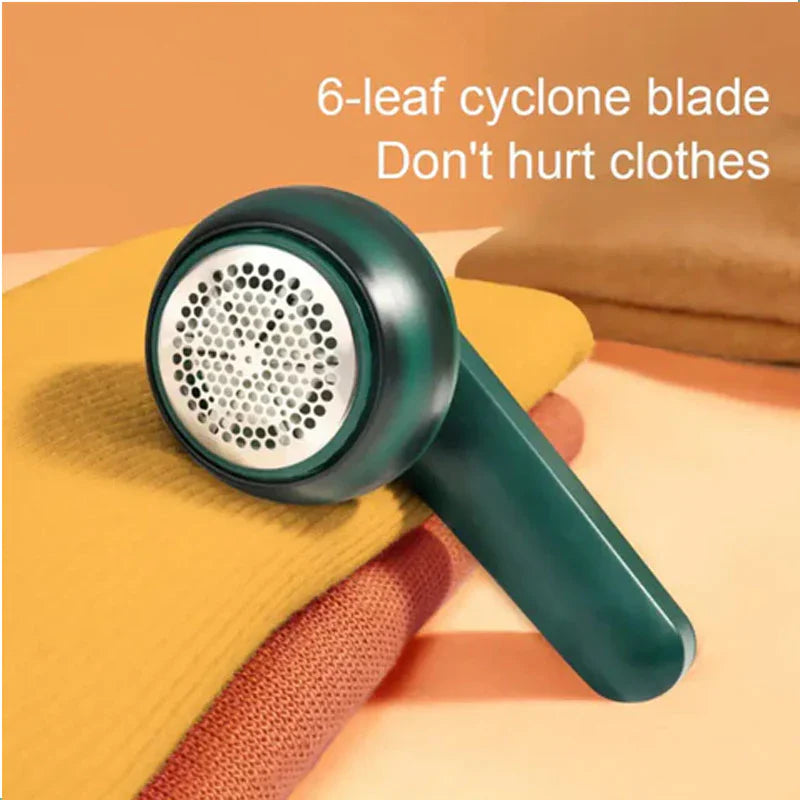 Electric fabric shaver with 6-leaf cyclone blade resting on a folded yellow sweater