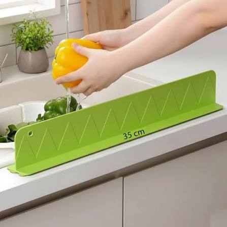 Green 35 cm sink splash guard keeping countertop dry while washing vegetables